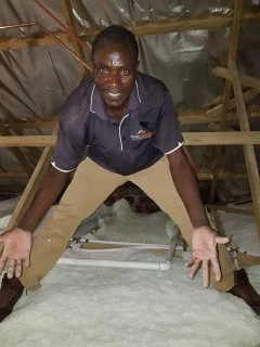 Polyester insulation being fitted between timber roof members