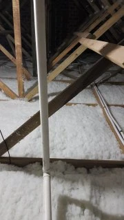 Polyester insulation being fitted between timber roof members