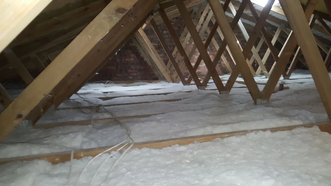 Polyester insulation being fitted between timber roof members